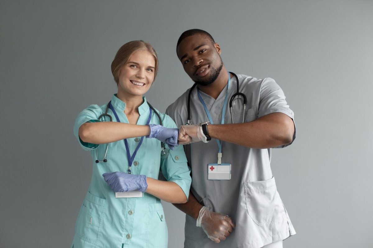 Enfermeiro e enfermeira sorrindo e se cumprimentando
