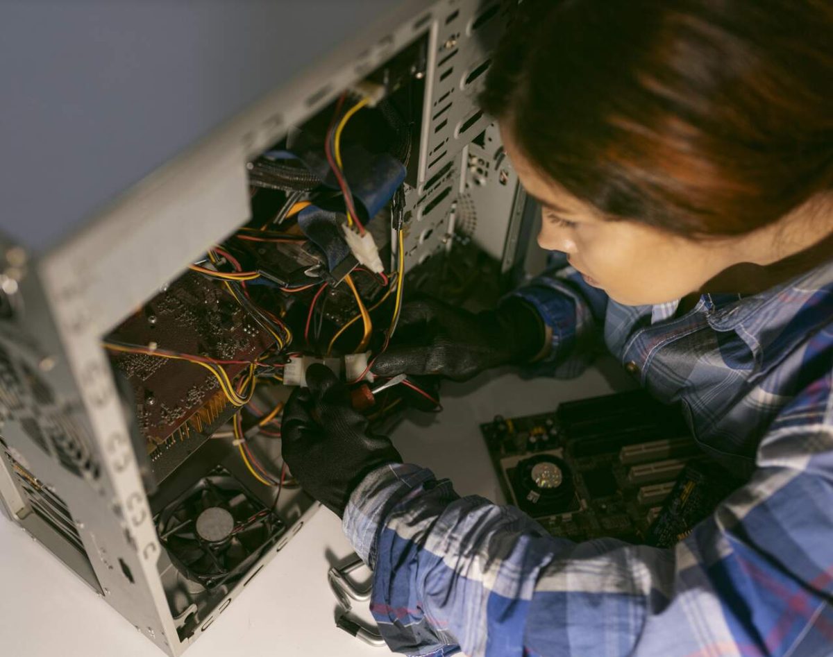 Mulher trabalhando com parte elétrica de CPU de computador 