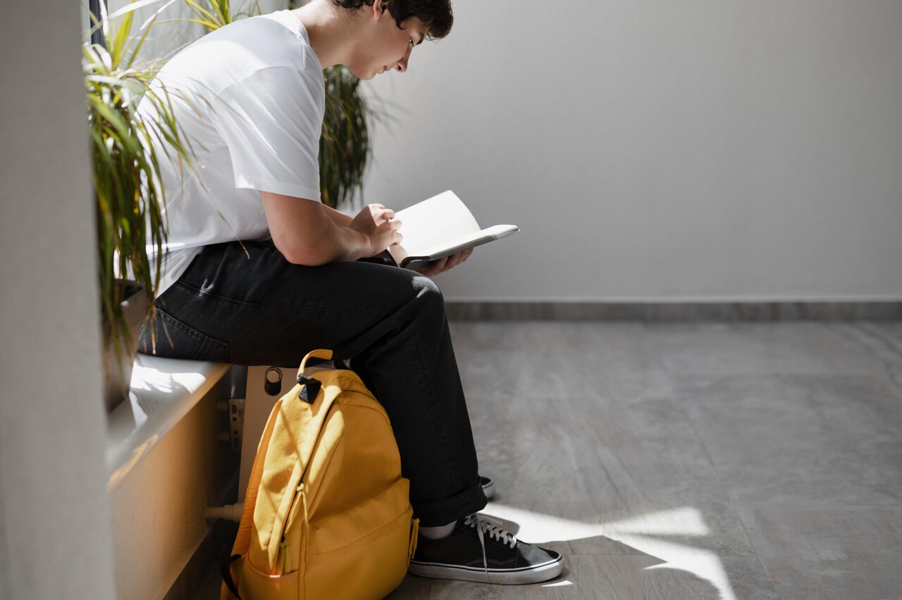 Estudante sentado com mochila e caderno estuda para ETEC 2024